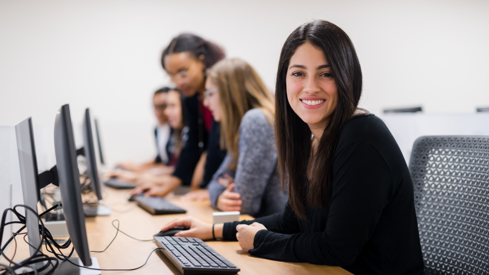 Smiling young woman sitting at a computer
