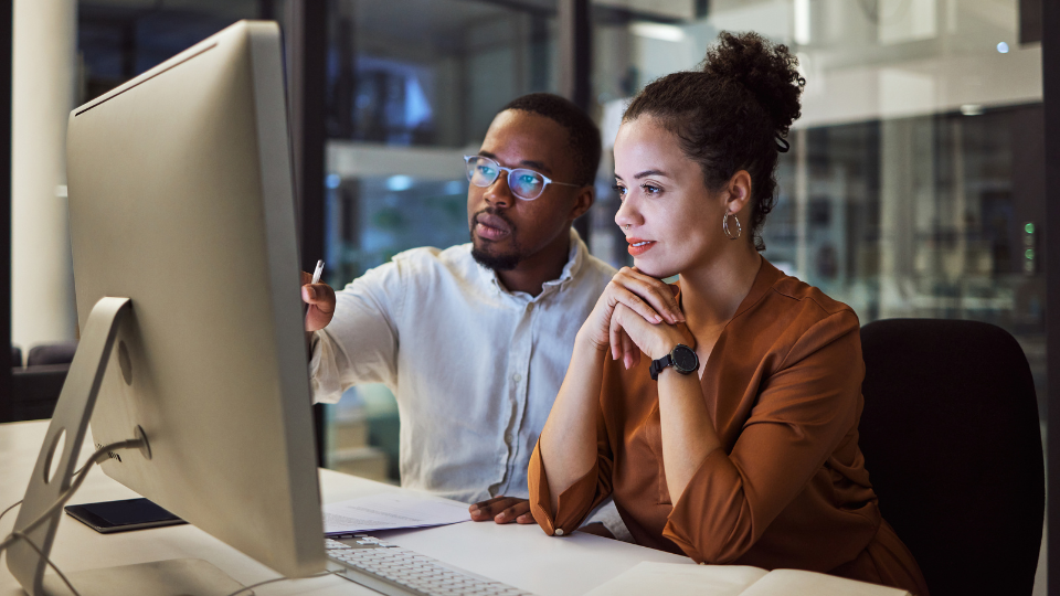 Two young professionals collaborating at a computer